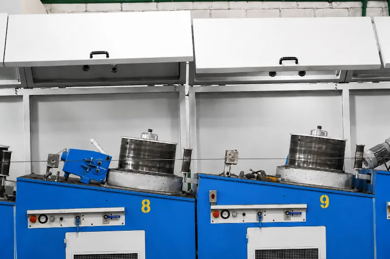 Equipamentos de trefilação da Laud Arames com cabines azuis numeradas em operação
